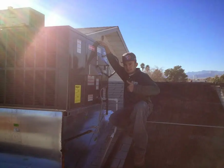 HVAC technician performing Air Duct Repair on a rooftop unit in Amarillo